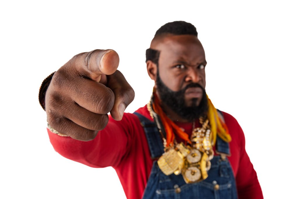 Mr. T pointing toward the camera in a red jacket and gold chains