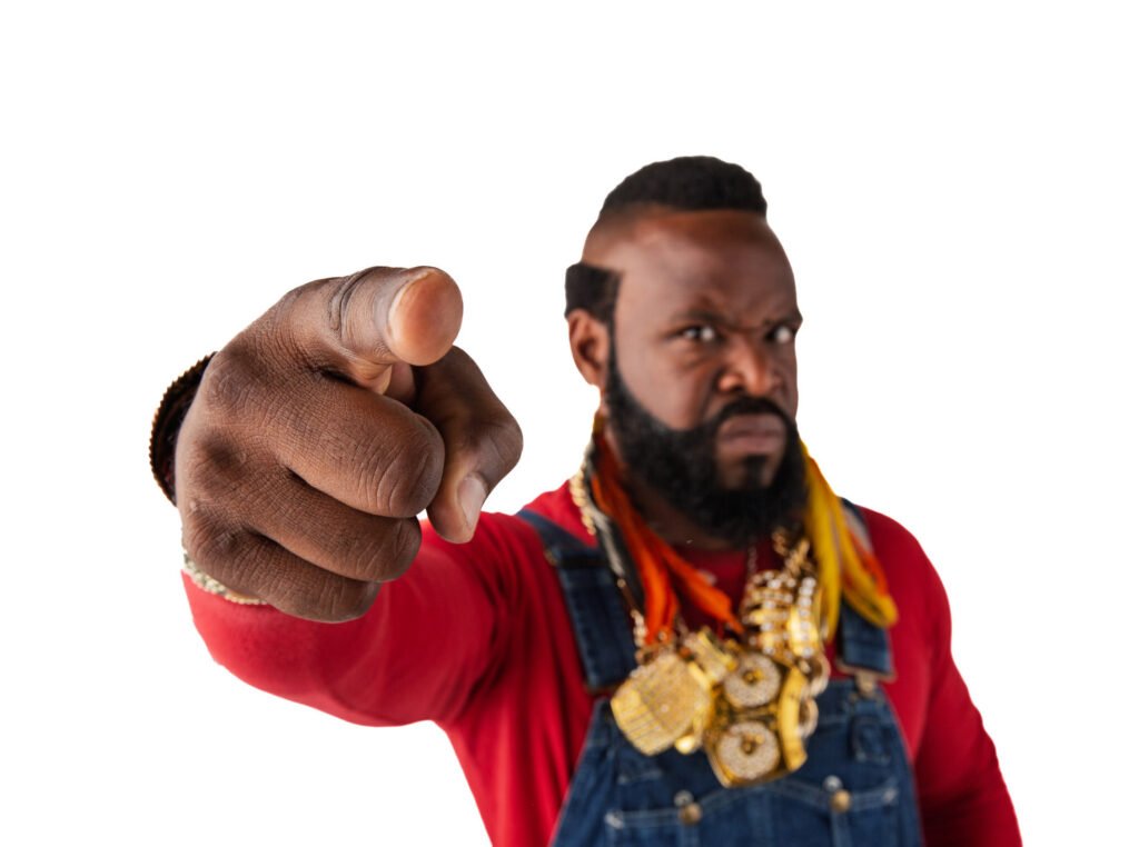 Mr. T pointing toward the camera in a red jacket and gold chains