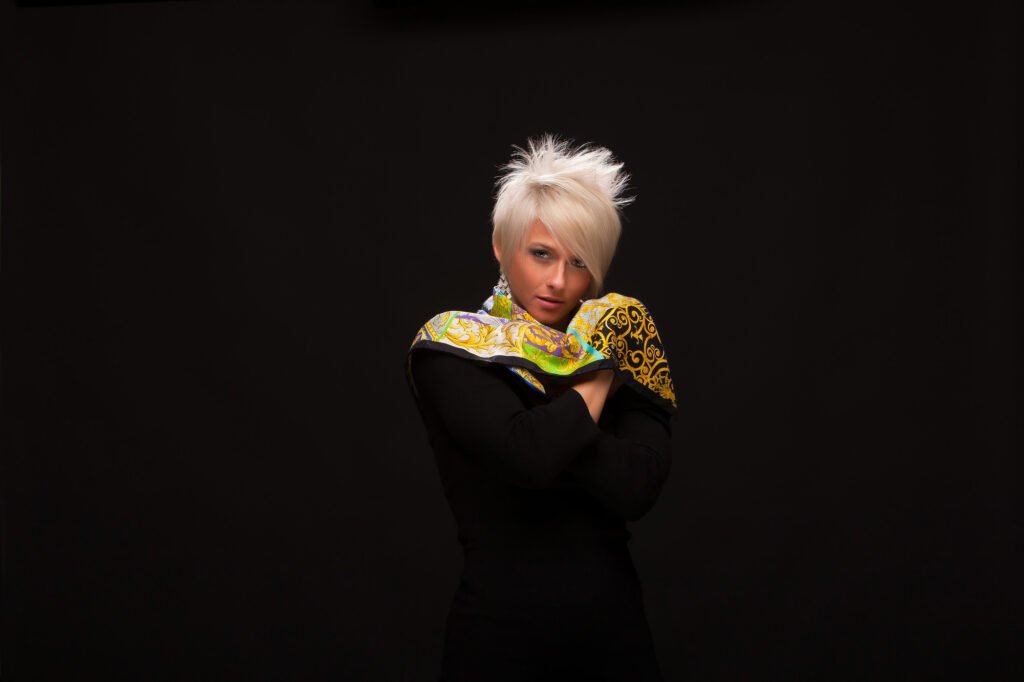 Woman in black clothing with a bright patterned scarf