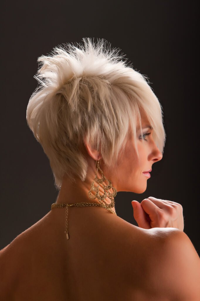 Profile portrait showing short blonde hair and a bare shoulder