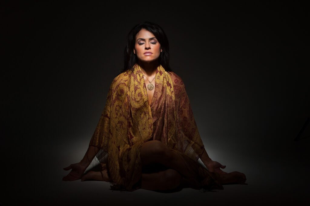 Seated fashion portrait with a flowing gold-patterned wrap