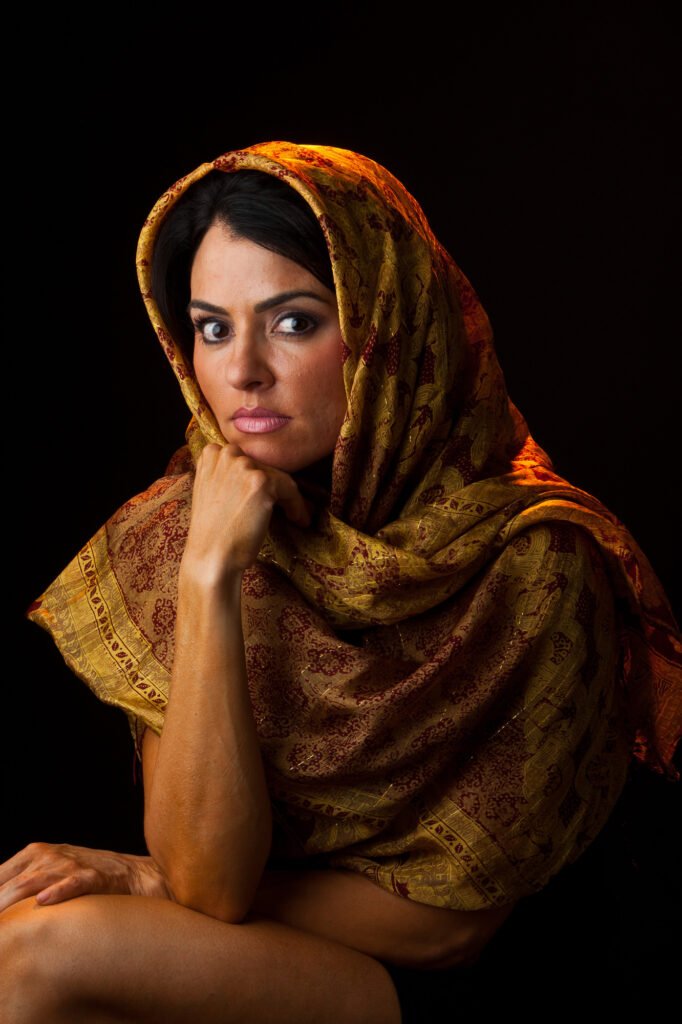 Woman wearing a gold-patterned scarf over her head