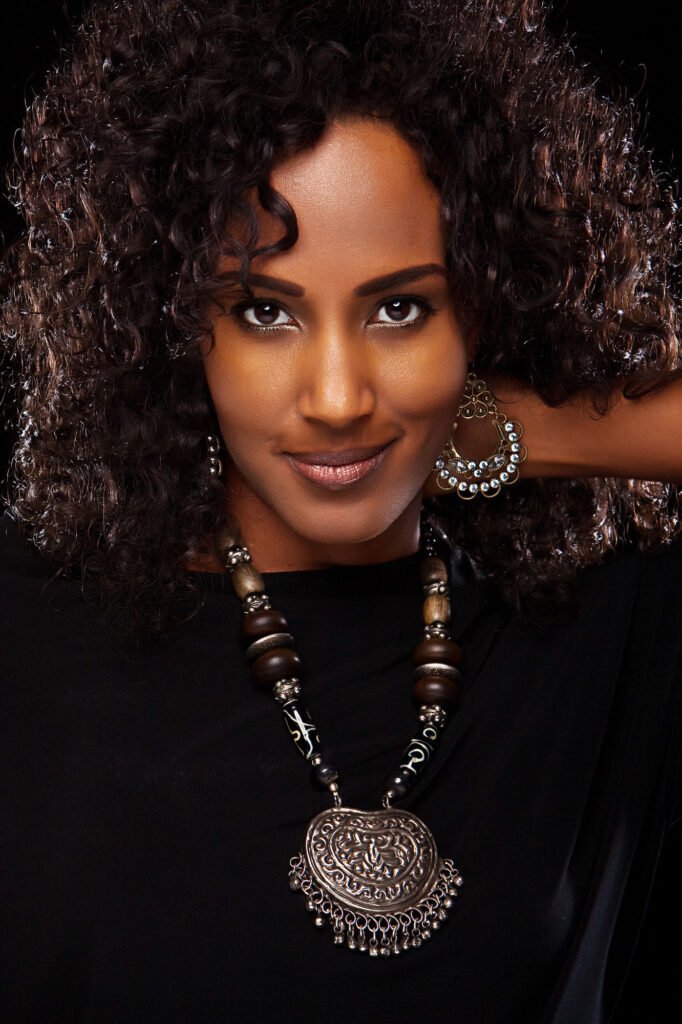 Woman with curly hair wearing a large circular pendant