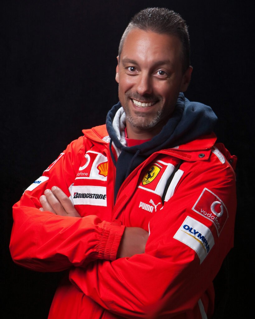 Man in a red racing jacket with his arms crossed