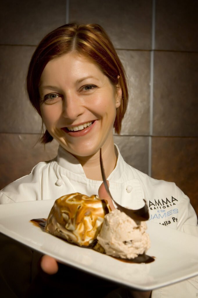 Chef in a white coat presenting a plated dish