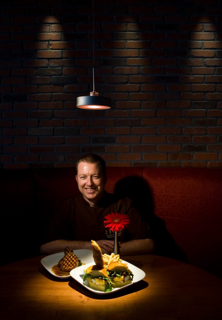Restaurant portrait of a man seated behind a plated meal
