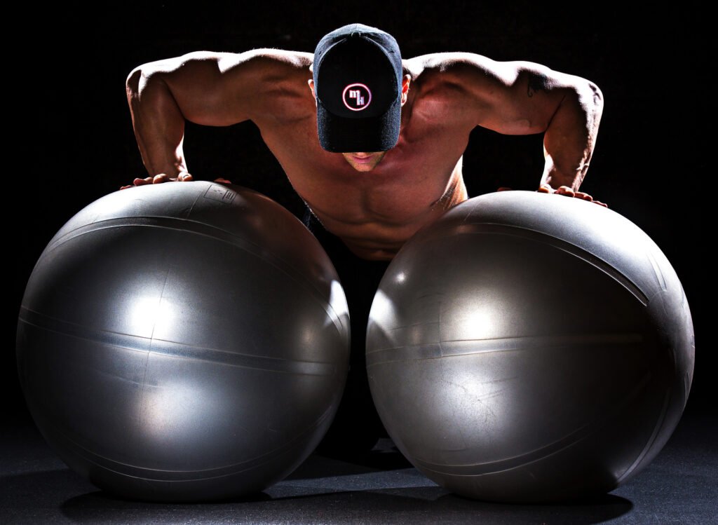 Athlete performing a push-up between two exercise balls