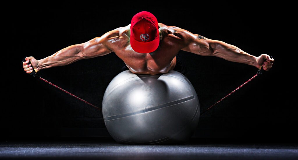 Athlete stretching resistance bands over an exercise ball