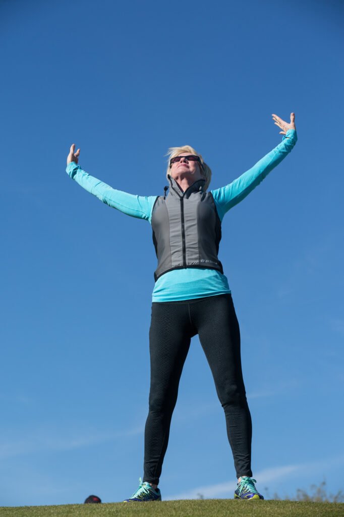 Woman stretching outdoors against a clear blue sky