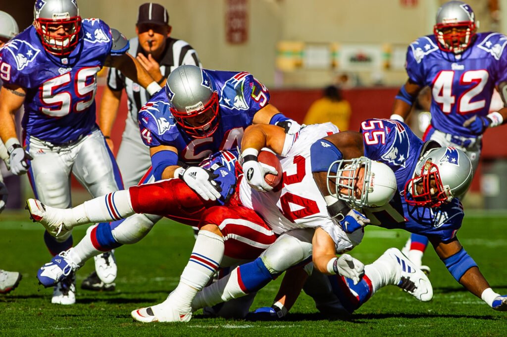 Football ball carrier brought down among several defenders
