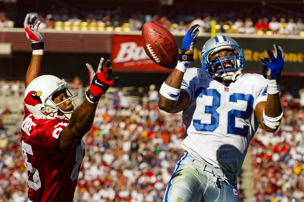 Football players reaching for the ball near the end zone
