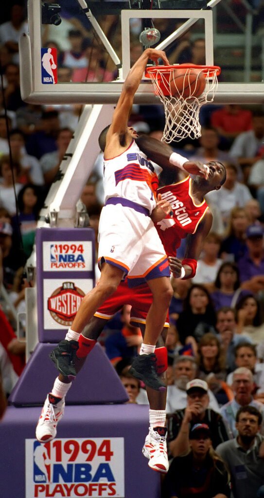 Basketball player attacking the basket above a defender