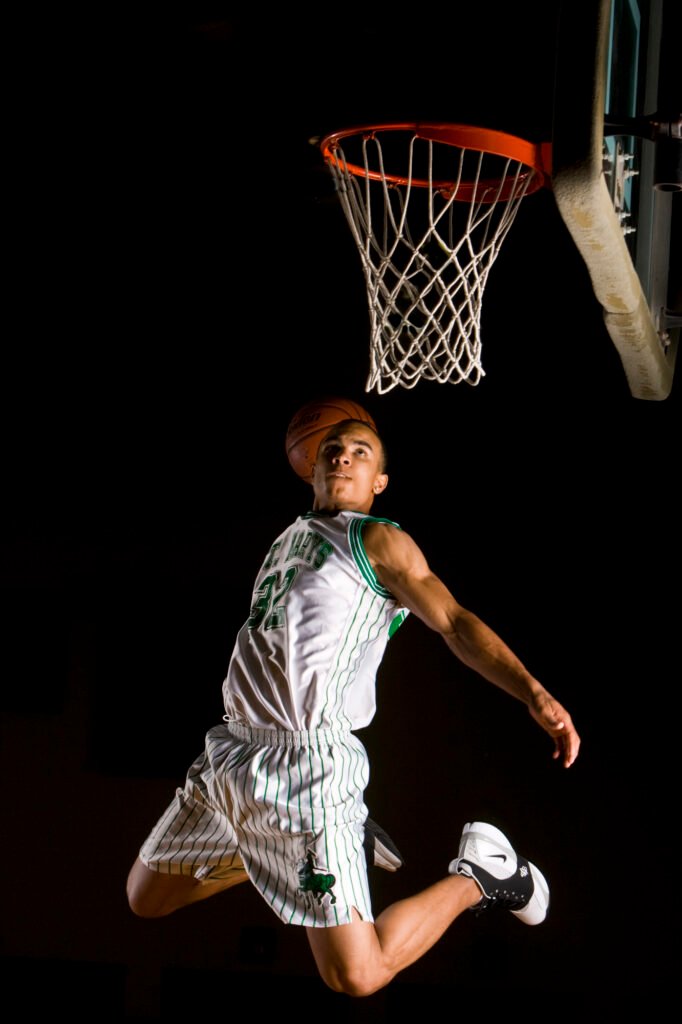 Basketball player looking up at the hoop after a jump