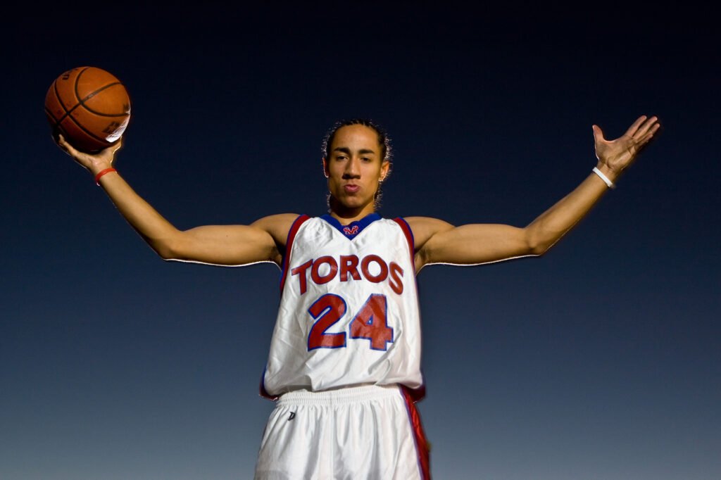 Basketball player holding a ball with both arms extended