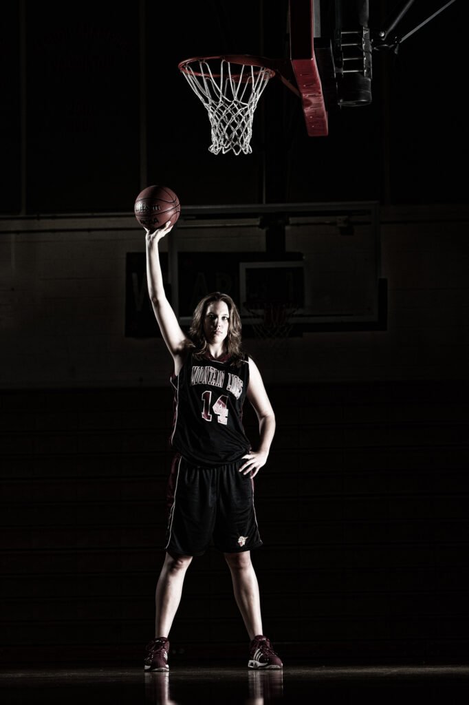Basketball player reaching upward beneath a hoop