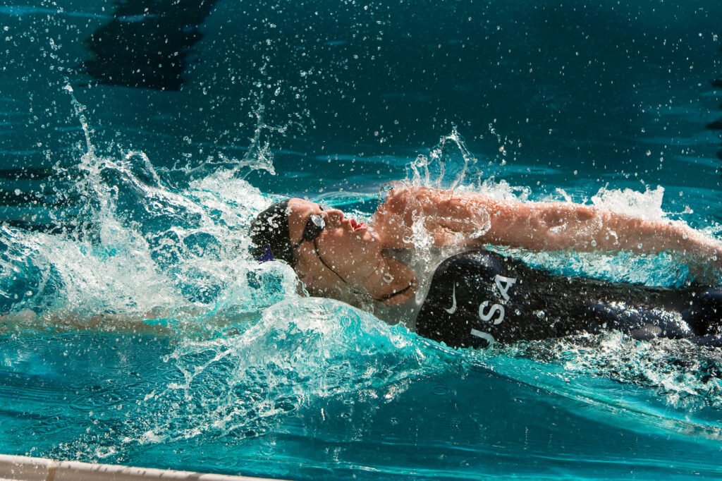 Swimmer moving through turquoise water with one arm extended