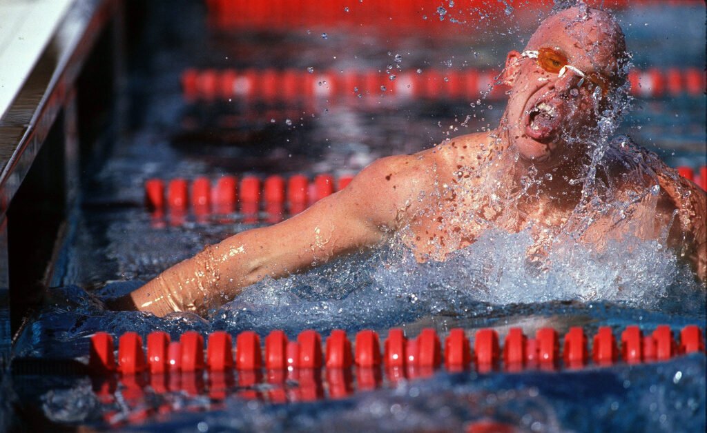 Swimmer racing between red lane dividers