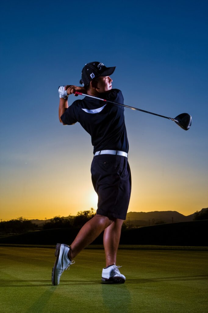 Golfer silhouetted on a green at sunset