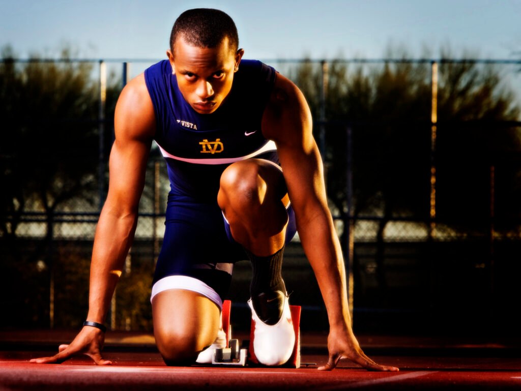 Sprinter crouched at the starting line in warm evening light
